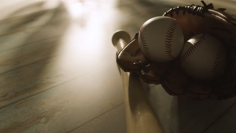 Backlit-Close-Up-Studio-Baseball-Still-Life-With-Bat-Ball-And-Catchers-Mitt-On-Aged-Wooden-Floor-1